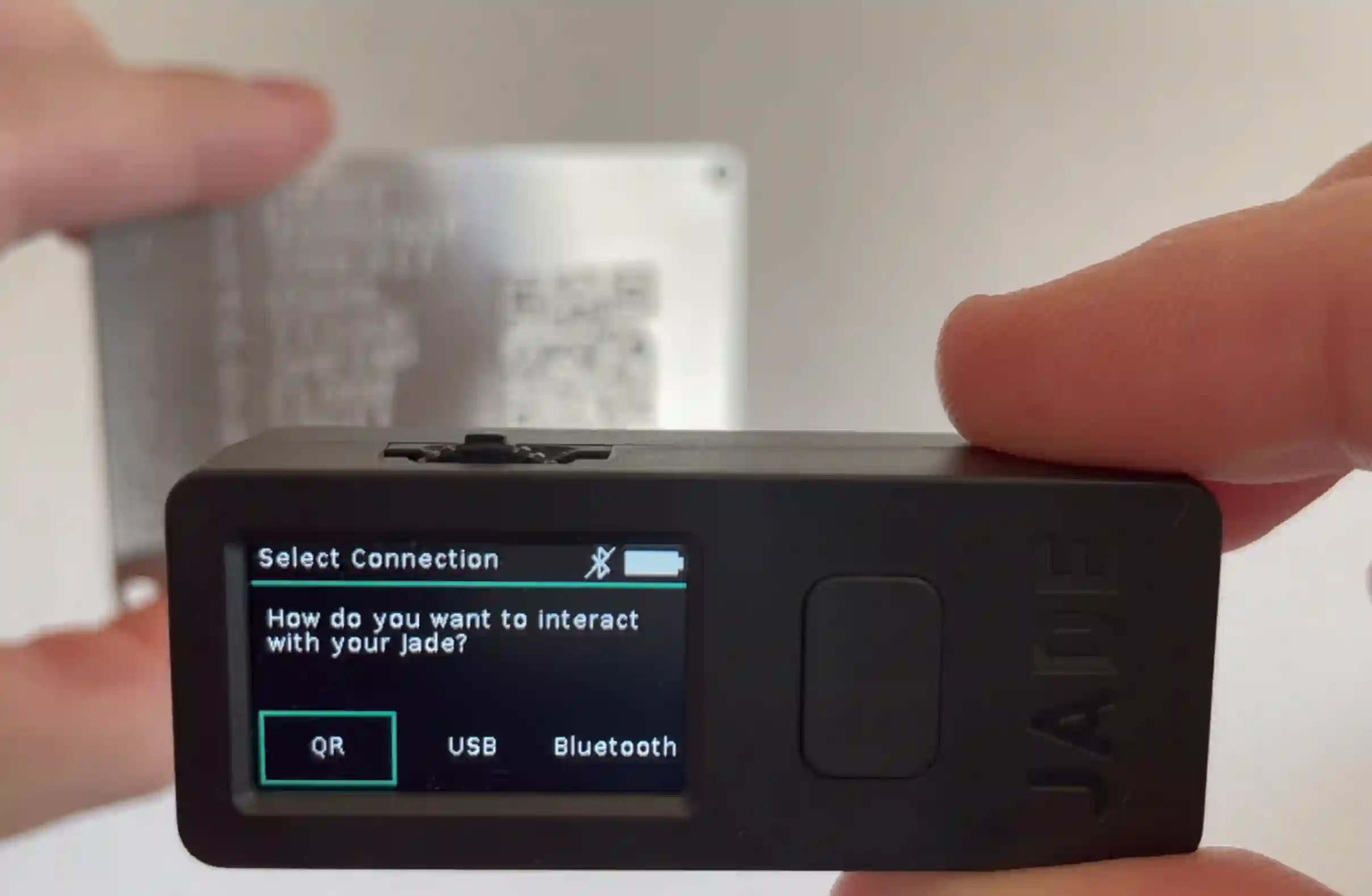 Blockstream Jade scanning a CompactSeedQR from a SeedHammer backup plate